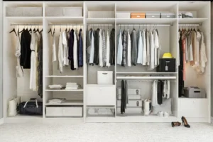Modern white wardrobe with neatly arranged clothes and storage boxes.